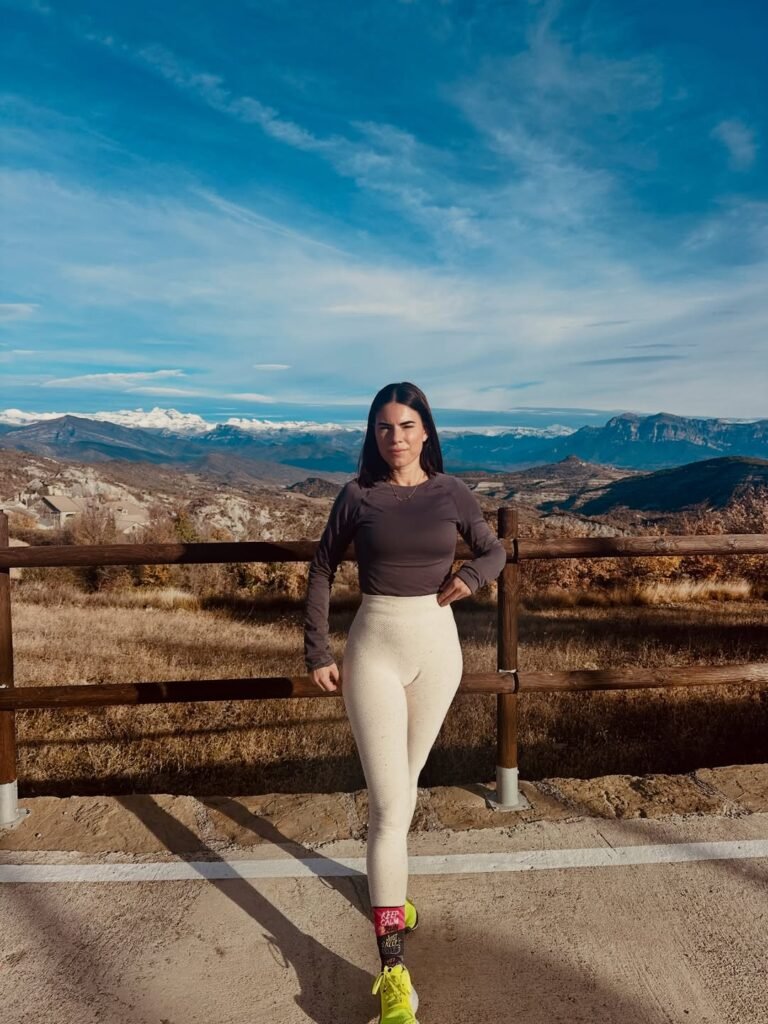 Laura Toledo posando en un paisaje montañoso, con ropa deportiva y una actitud confiada.