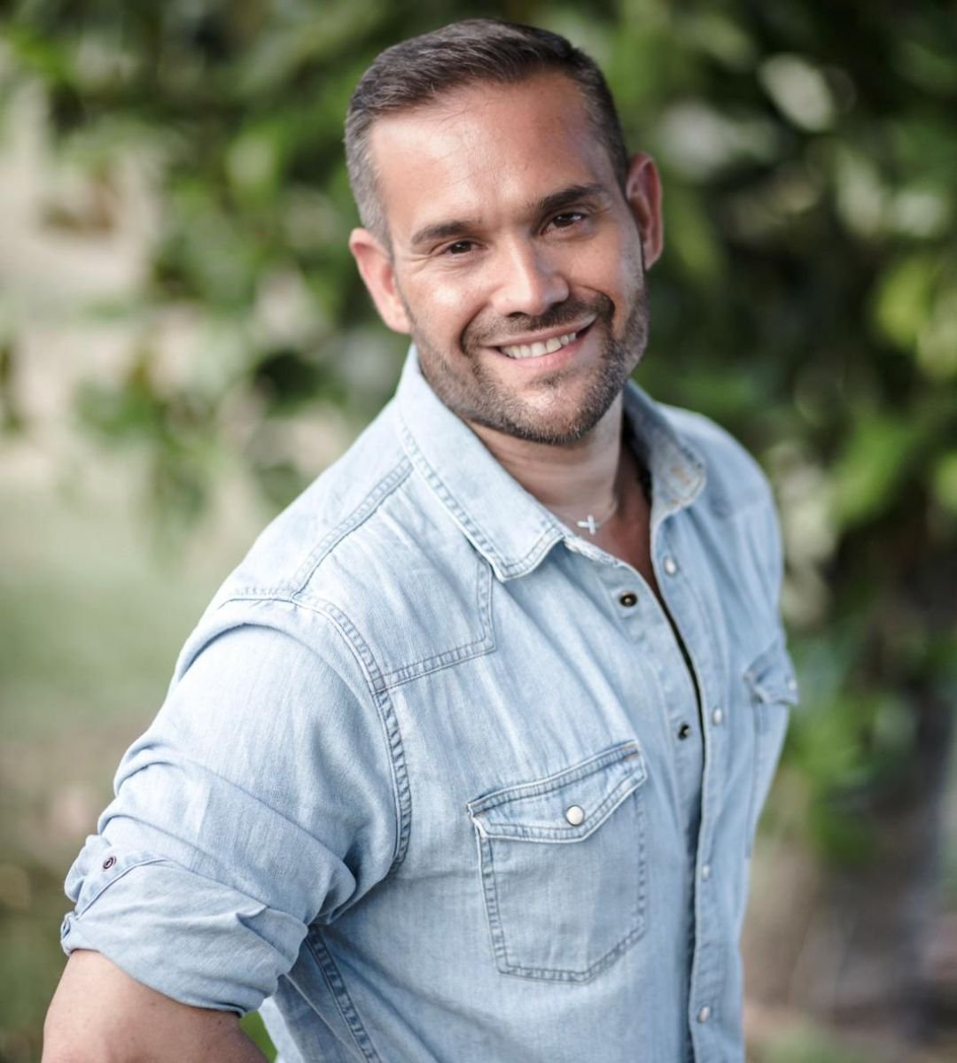 David del Moral sonriendo al aire libre con camisa de mezclilla, en colaboración con la Agencia de Marketing Digital Brilla Influencers y Comunicación.