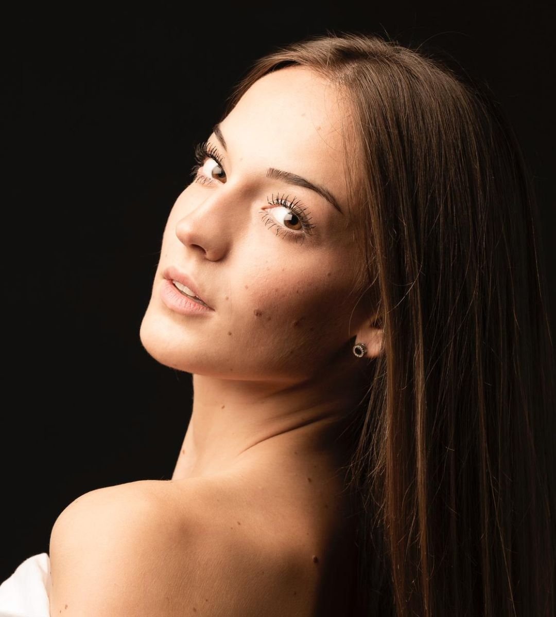 Laura Cárdenas en retrato artístico con fondo oscuro, en colaboración con la Agencia de Marketing Digital Brilla Influencers y Comunicación.