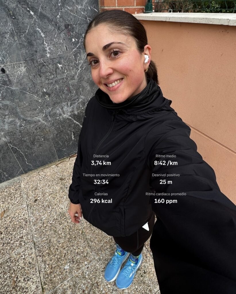 Alba García Diez sonriendo después de correr al aire libre, mostrando sus estadísticas de ejercicio en la pantalla del reloj.
