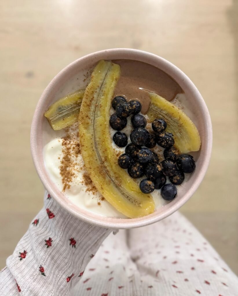 Plato saludable con yogur, plátano, arándanos y canela en la parte superior, capturado por Alba Garcia Díez.