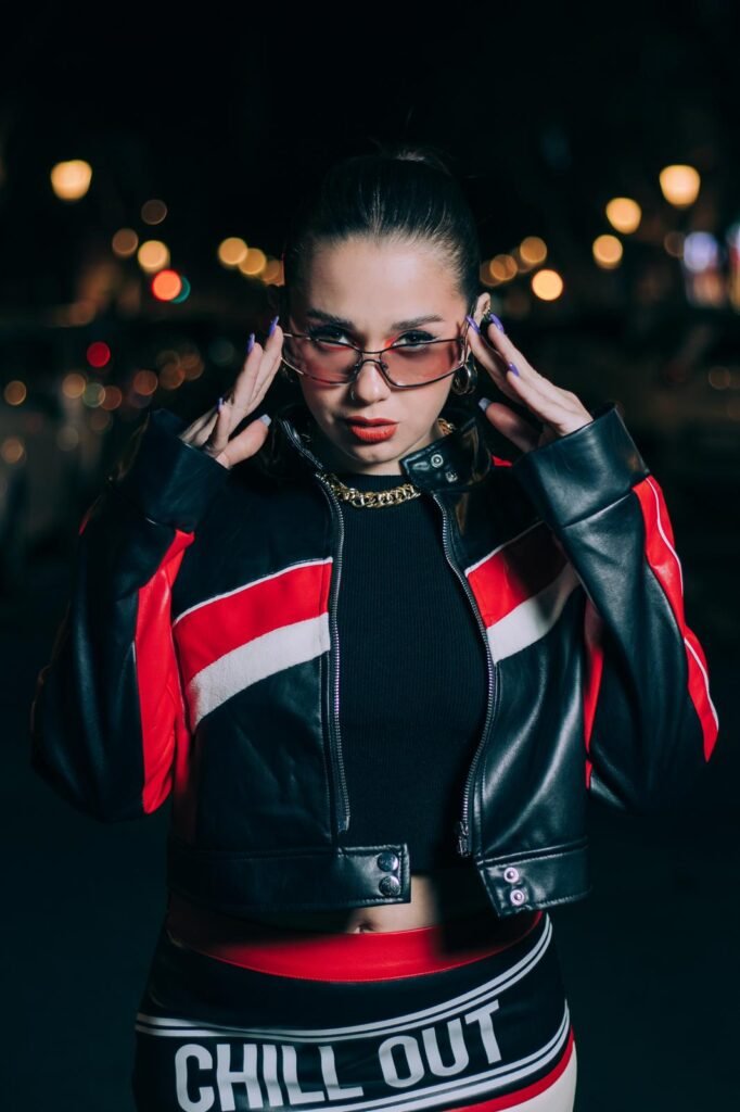 Bárbara Elena posando en la calle con chaqueta de cuero roja y pantalón corto, con gafas de sol.