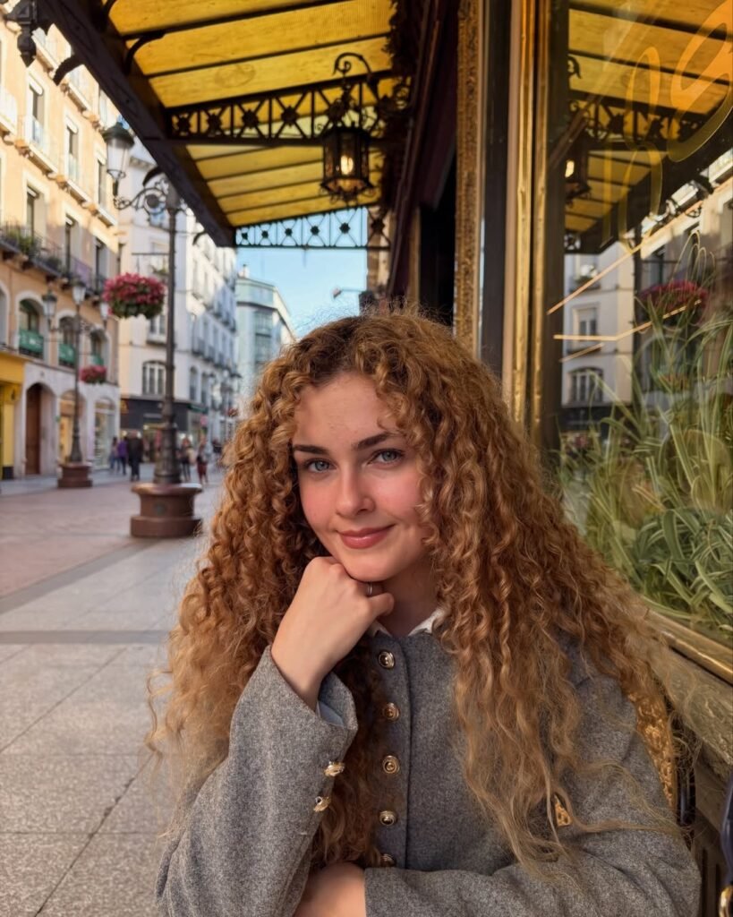 Cristina Ruiz Marin sonriendo con un fondo de un café con flores.