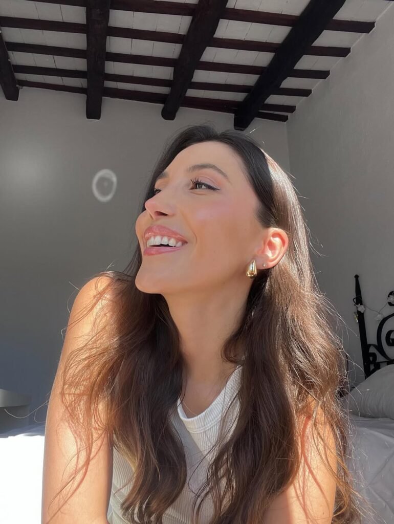 Eva Figueras Paguina sonriendo con luz natural, mostrando un look fresco y natural en interior. Agencia de marketing digital Brilla Influencers y Comunicación.