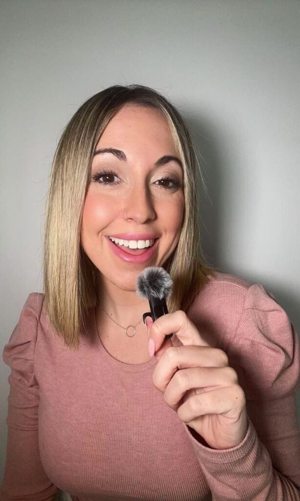 Laura Domínguez González sonriendo suavemente, sujetando un micrófono de peluche.