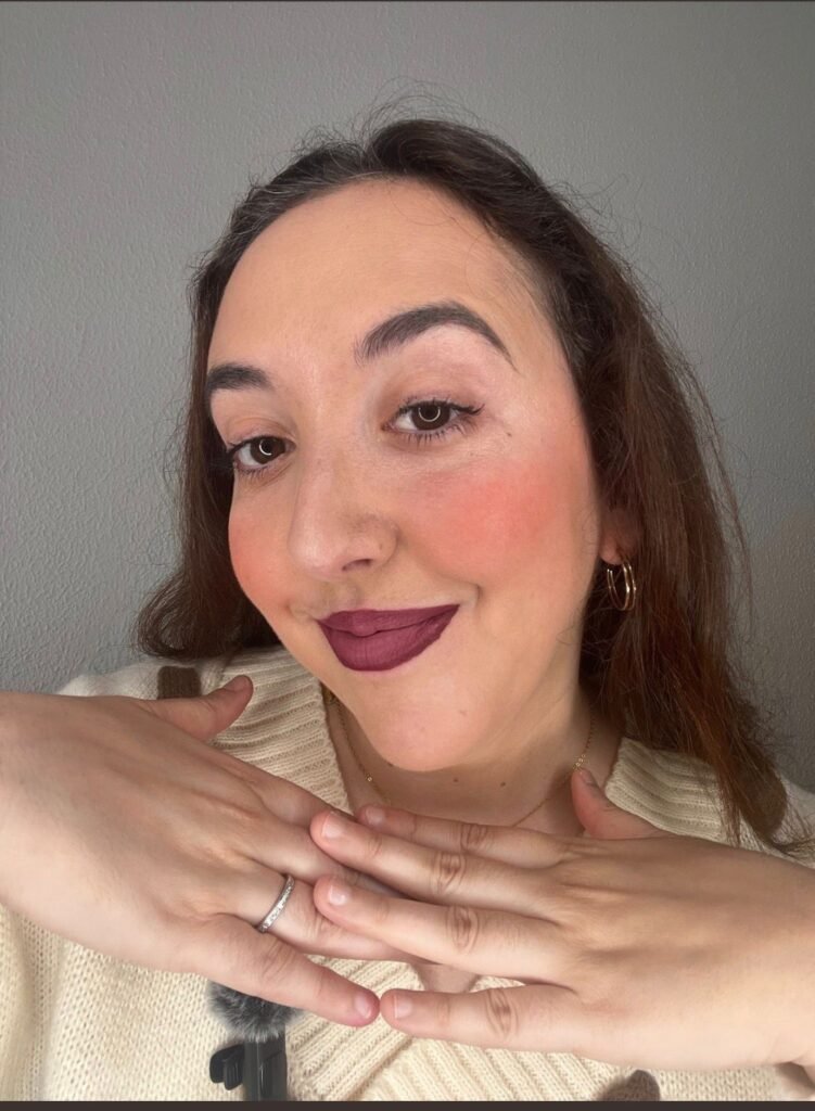 Lola Martín González con un conjunto de suéter blanco y labios rojos.
