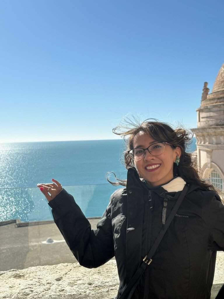 María del Carmen Ramírez, creadora UGC, disfrutando del paisaje en la playa, con vista al mar y vestimenta cómoda para contenido de viajes.