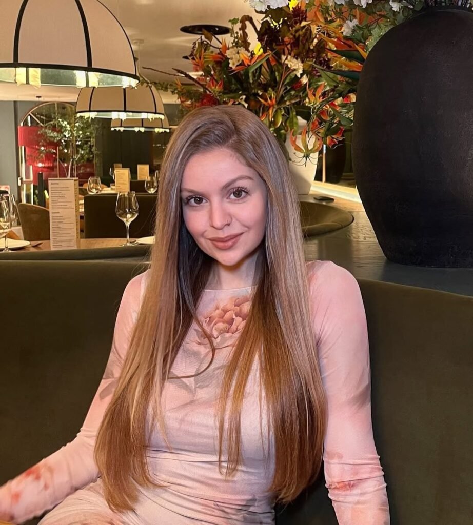 María Navarro posando en un restaurante, con un vestido floral de tonos suaves. UGC elegante y sofisticado.