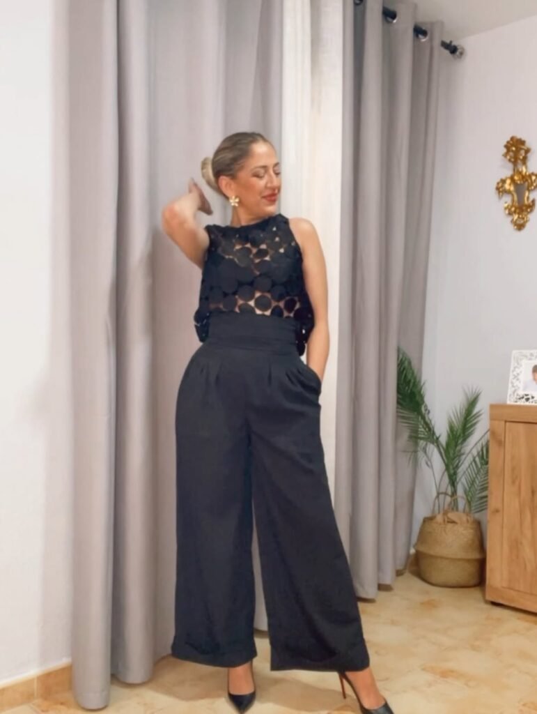 Noemí Bayona, creadora de contenido lifestyle conocida como Happy Nayo, posando con un look elegante negro en un entorno interior.