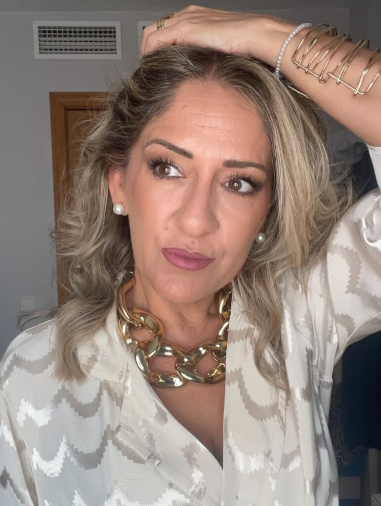Noemí Bayona, creadora de contenido lifestyle conocida como Happy Nayo, posando con un look elegante y accesorios dorados.