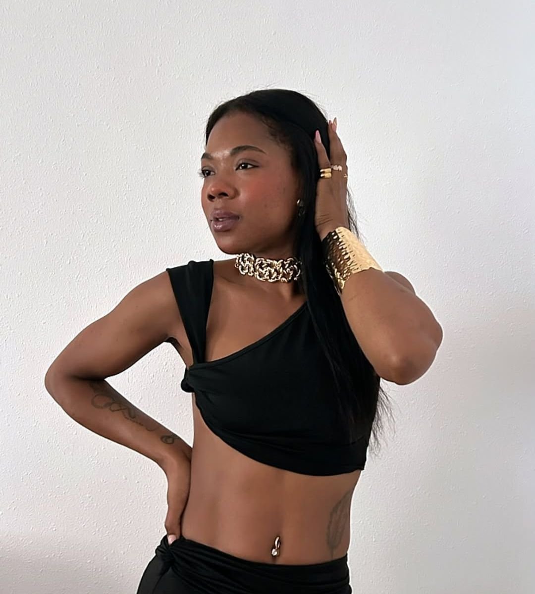 Andrea Aranda luciendo un look con top negro y joyas doradas, destacando su estilo y colaborando con la Agencia de Marketing Digital Brilla Influencers y Comunicación.