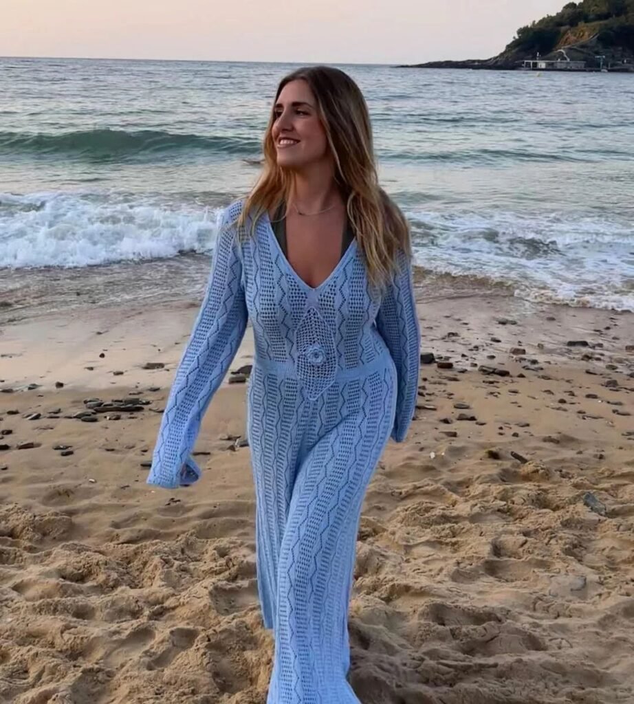 Carolina Gallado caminando por la playa con un vestido azul, colaborando con la Agencia de Marketing Digital Brilla Influencers y Comunicación