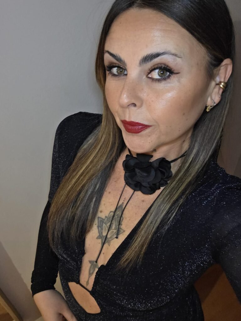 Veronica Villegas, creadora UGC con un elegante vestido negro y labios rojos.