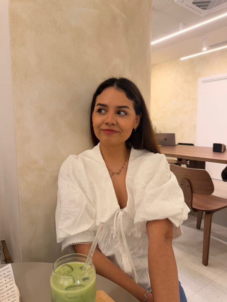 Desiree Vela, creadora de contenido y UGC, posando con una bebida refrescante, destacando su estilo relajado y auténtico.