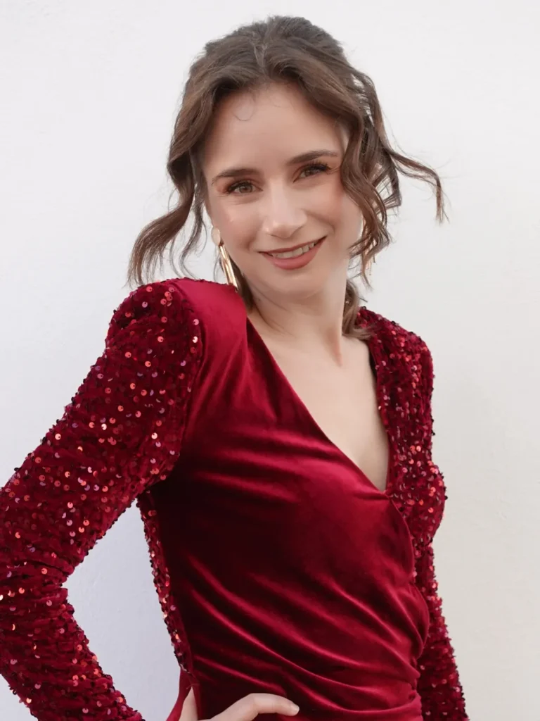 mujer con vestido rojo elegante posando sonriente en fotografía lifestyle