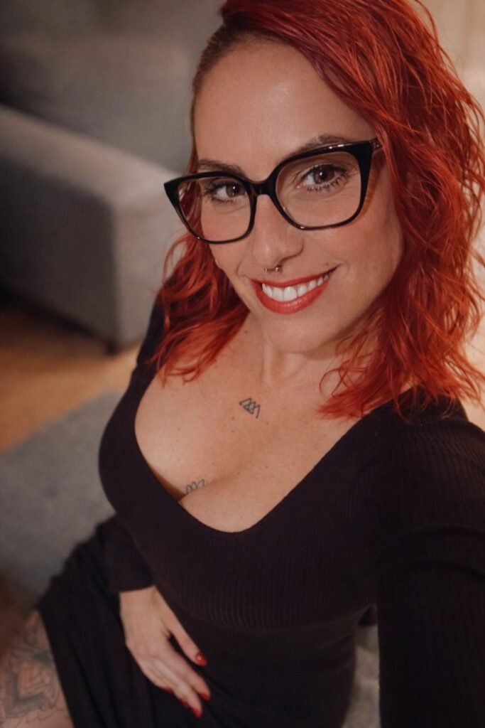 Susanna Ayala Garcia con gafas y una camisa de manga larga negra, sonriendo.