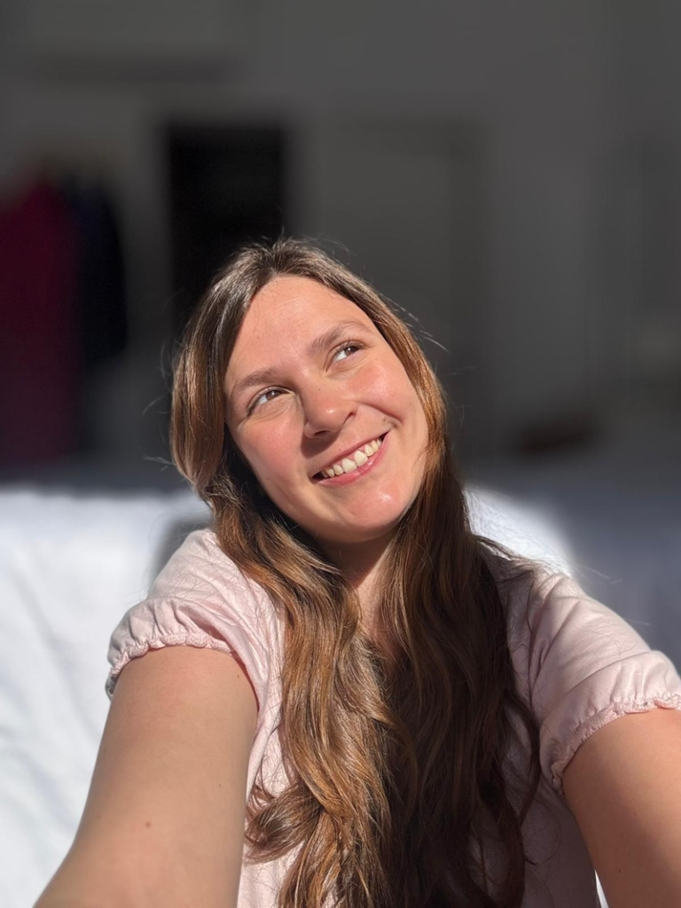 Casandra Benassar sonriendo, cabello largo castaño, fondo neutro, luz natural, expresión amigable y cercana.