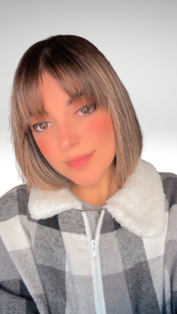 Retrato en primer plano de Natalia Márquez Sánchez con corte de pelo bob con flequillo y chaqueta de cuadros con cuello de borreguillo.