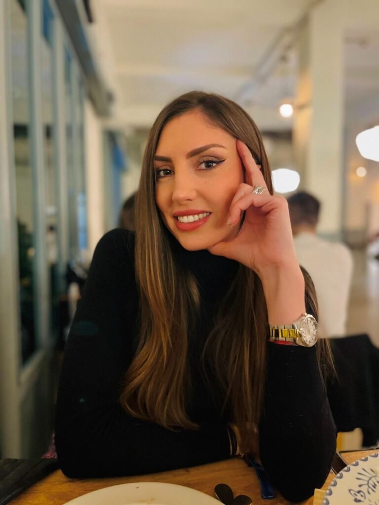 María posando en restaurante, con cabello largo y suelto, mostrando estilo natural y cercano.