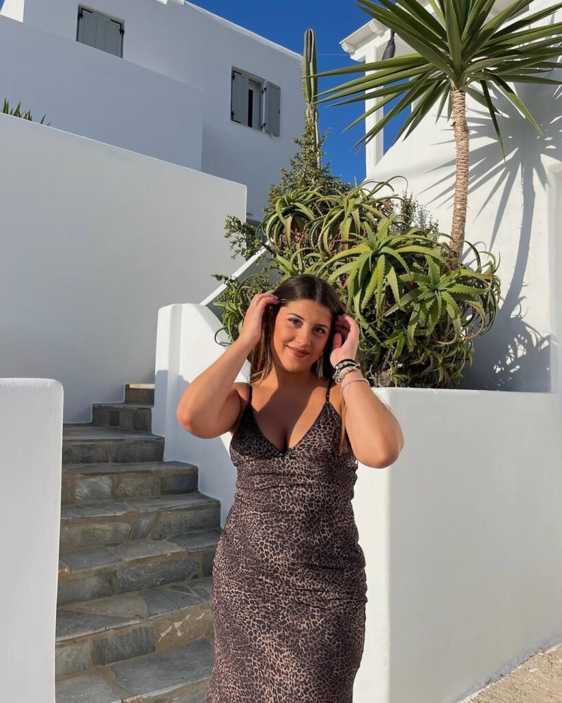 Lucía Pérez García posando al aire libre con vestido estampado en un entorno mediterráneo, creando contenido UGC lifestyle, moda y viajes.