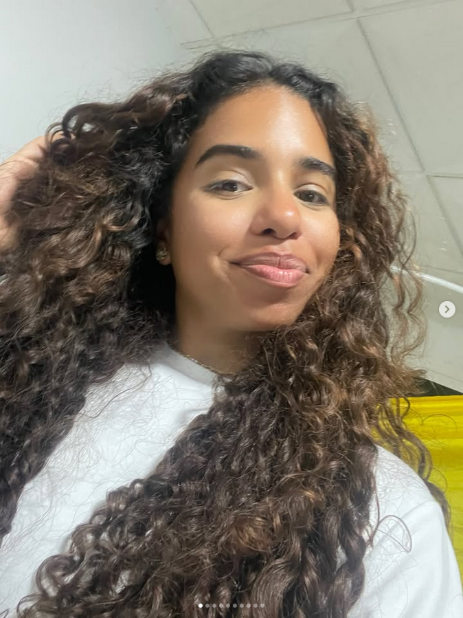 Creadora de contenido con cabello rizado posando en una fotografía natural para redes sociales
