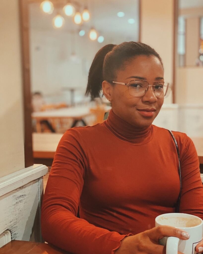Rosa Alcázar Morales de Valencia tomando un café, con jersey naranja y gafas, estilo cercano y natural