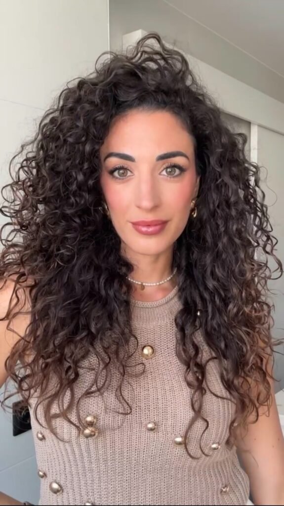 Soraya Fernández mostrando su look de maquillaje con peinado rizado y estilo elegante