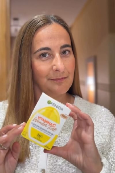Susana Fernández Elena mostrando el tónico Garnier Vitamin C Wonder Tonic con caja amarilla."