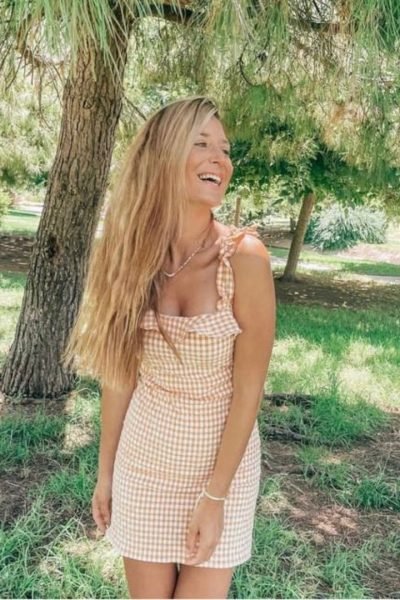 Thais García Más, creadora UGC de lifestyle y moda, con vestido de cuadros en un entorno natural al aire libre | Agencia Brilla Influencers