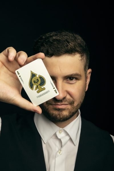 Hombre mostrando carta de póker As de espadas - Fotografía profesional