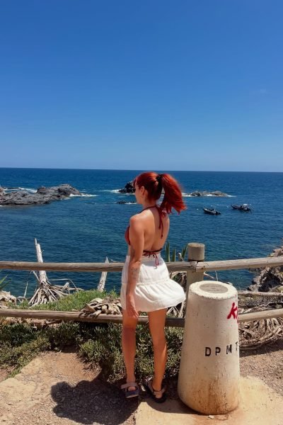 Adriana Colodro mirando el mar creando contenido lifestyle en la costa