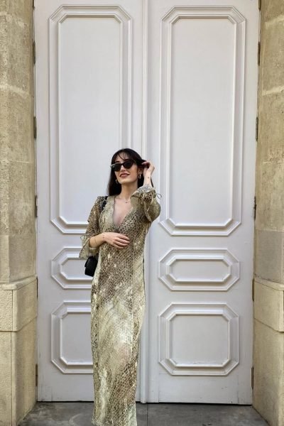 Ana Flores Campos luciendo un vestido estampado animal print y gafas de sol frente a una puerta clásica en una sesión de moda elegante.
