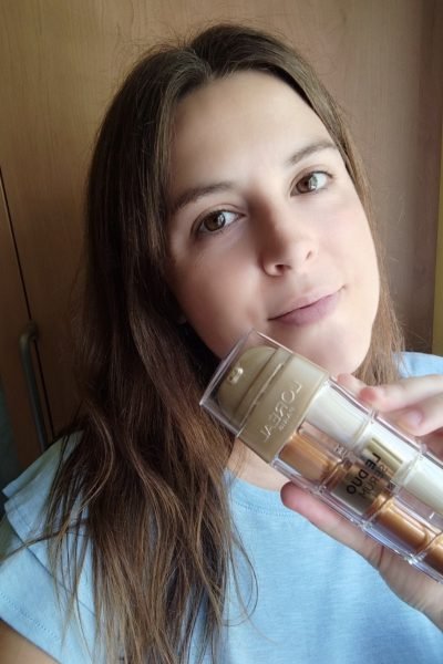 Andrea Renau Vázquez sonríe frente a la cámara sosteniendo un envase de producto cosmético, mostrando cercanía y autenticidad como creadora de contenido UGC.