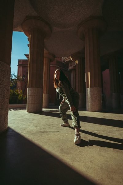 Arantxa Styles en un look deportivo bajo columnas arquitectónicas con luz del sol.