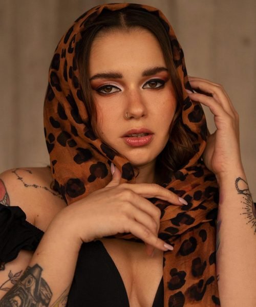 Bárbara Elena con un pañuelo leopardo sobre los hombros, mostrando un look natural y elegante.