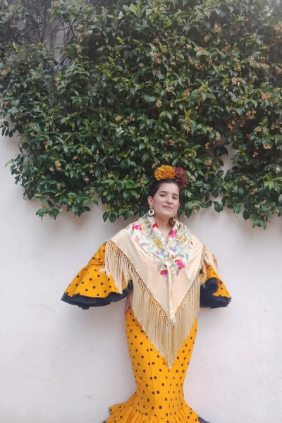 María del Valle del Moral Cobija con vestido de flamenca amarillo de lunares, mantón bordado y flores | Agencia Brilla Influencers