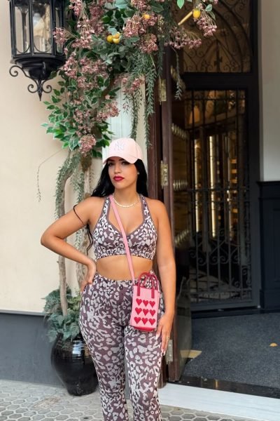 Carolina Vera con conjunto de leopardo, bolso rosa y gorra, en un fondo urbano. UGC de moda casual.