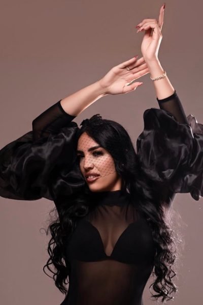 Carolina Vera posando con un vestido negro con detalles de tul, peinada con ondas. UGC de estilo sofisticado.