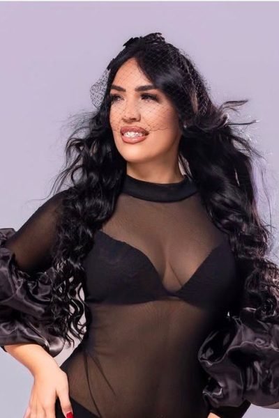 Carolina Vera con vestido negro y detalles de tul, posando con elegancia. UGC de moda sofisticada.