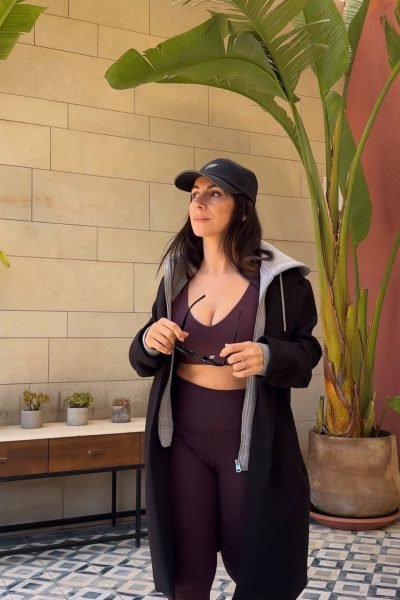 Cinzia Ledonne con ropa deportiva, posando con plantas de fondo.