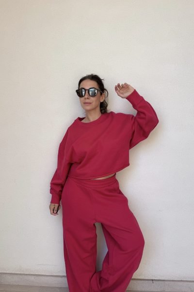 Cinzia Ledonne posando con gafas de sol negras y conjunto deportivo rosa.