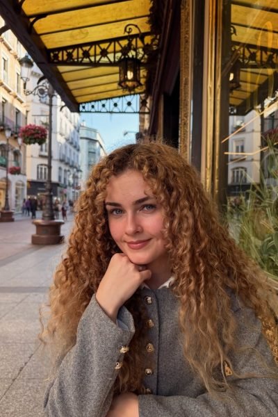 Cristina Ruiz Marin sonriendo con un fondo de un café con flores.