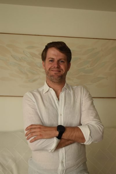 Edu Fairen usando ordenador portátil con camisa blanca, sentado en oficina.