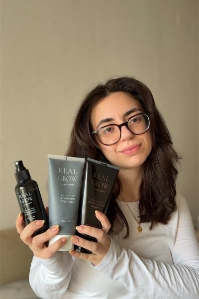 Esther Zecchin mostrando productos capilares Real Grow para el cuidado, fortalecimiento y volumen del cabello.