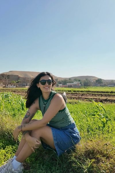 Fátima del Pilar sentada en el campo verde, con un look relajado y cómodo, rodeada de naturaleza.