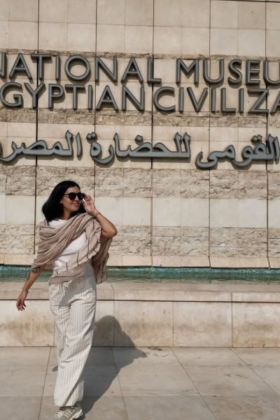 Fátima del Pilar caminando con gafas de sol frente al Museo Nacional de Civilización Egipcia.