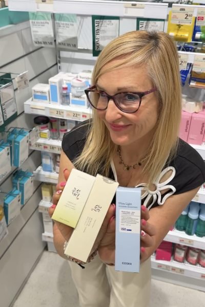 Mujer sosteniendo productos de cuidado personal en farmacia