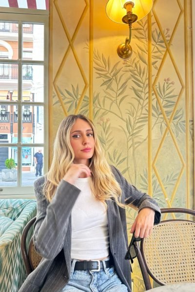 Gina Martínez Madramany en una cafetería con estilo elegante, creando contenido UGC de lifestyle y cultura para Agencia Brilla.
