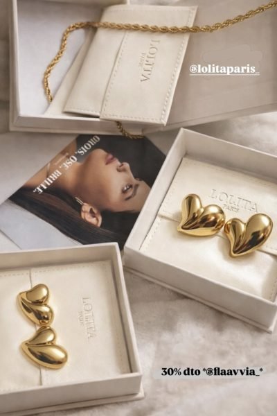 Pendientes y collar dorado de la marca Lolita Paris en cajas de regalo blancas, sobre fondo neutro.