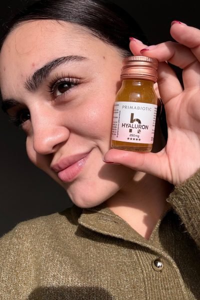 Primer plano de María sosteniendo un suplemento Primabiotic Hyaluron de 250 mg.